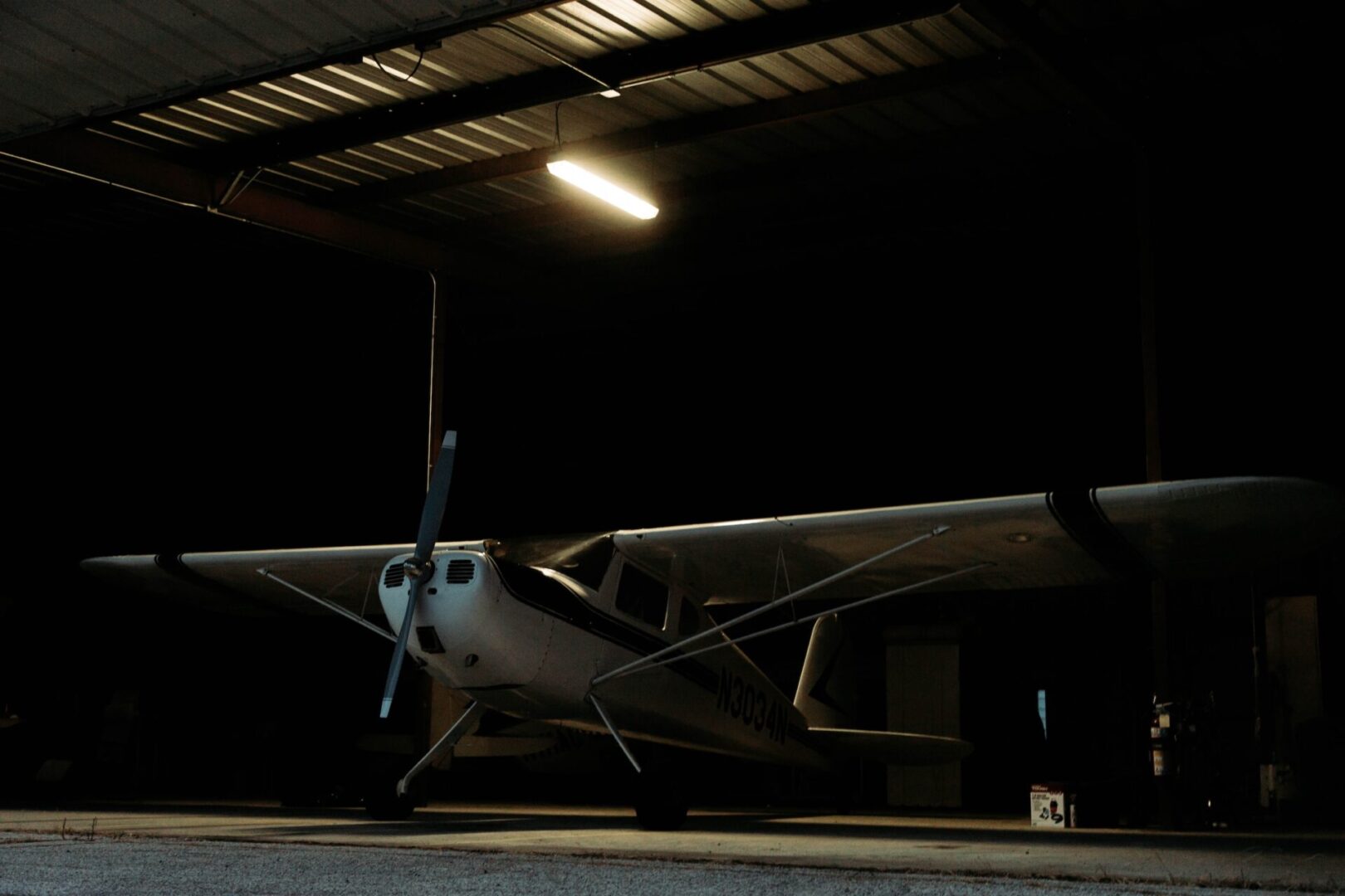 A small airplane parked in an empty hangar.